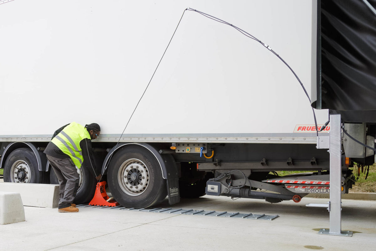 Mise en place du POWERCHOCK 3 par chauffeur camion devant roue